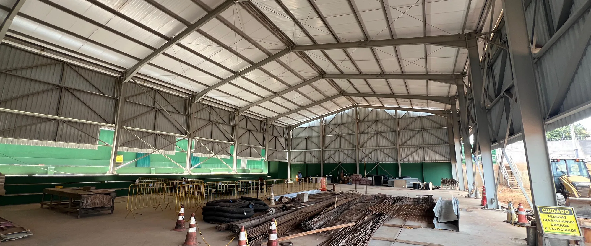 Interior de galpão com cobertura metálica de grande vão em fase de acabamento