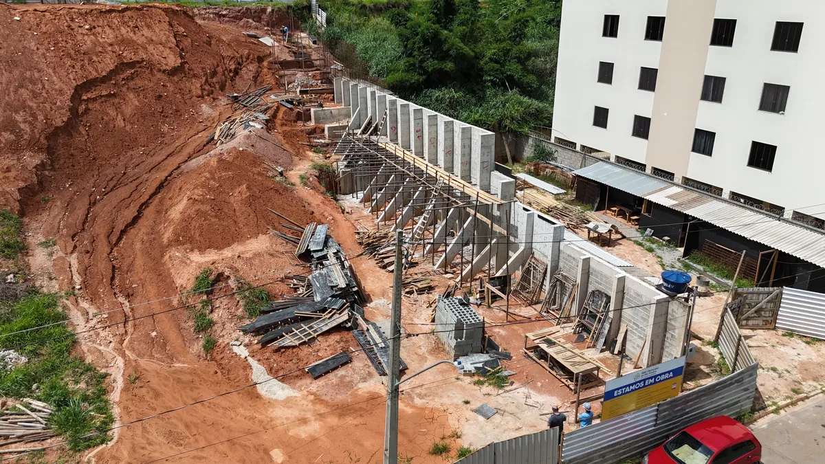 Execução de muro de arrimo em concreto ao longo de talude, vista aérea